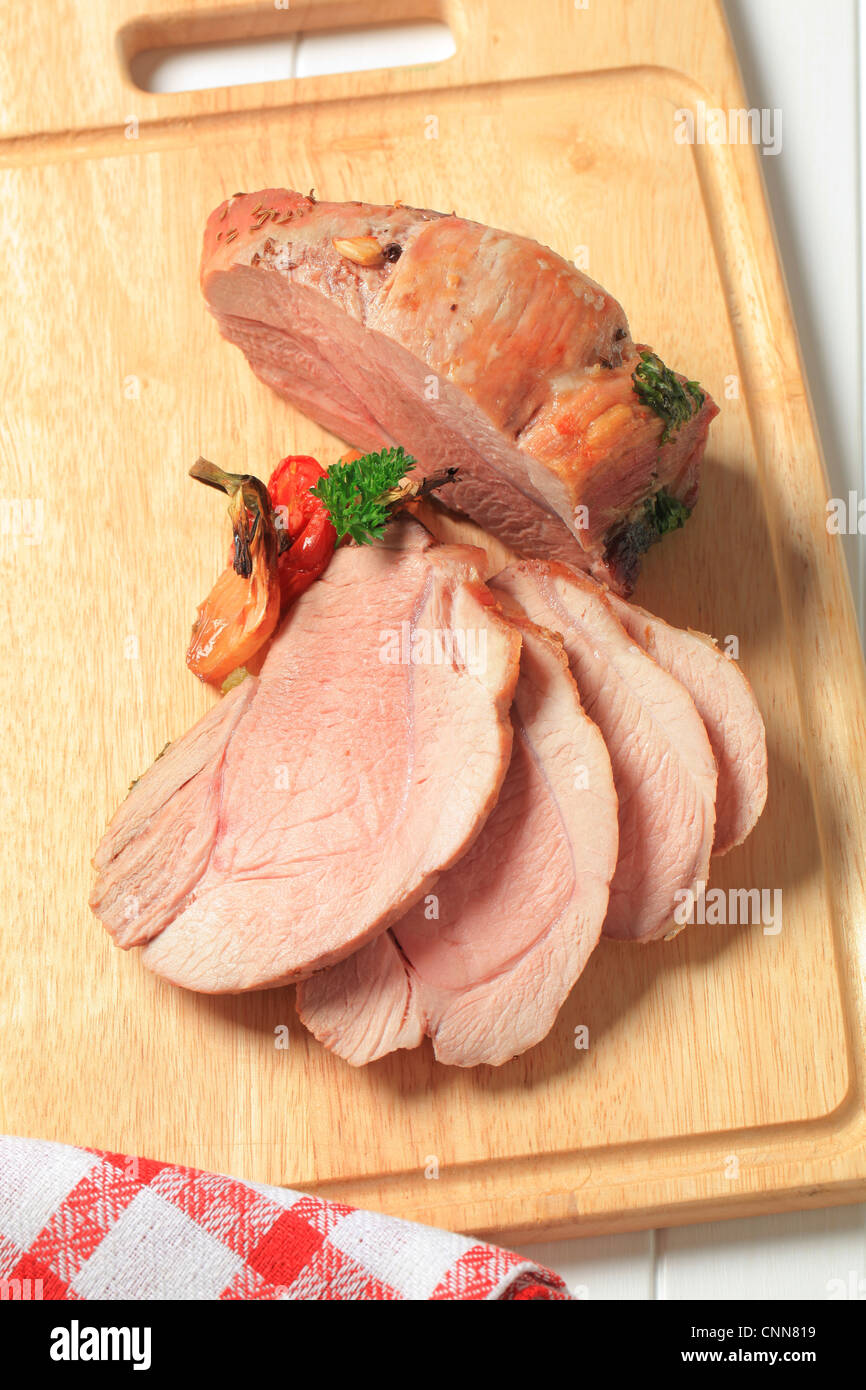 Scheiben von geröstetem Schweinefleisch auf ein Schneidebrett Stockfoto