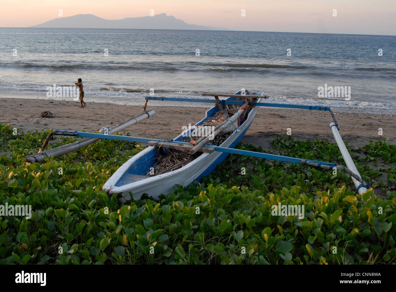 Ein traditionelles Auslegerboot Fischerboot am Strand in Dili Timor-Leste mit Insel Atauro am Horizont Stockfoto