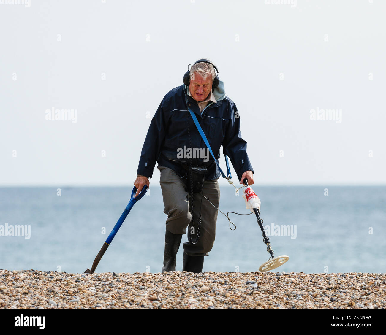 Mann mit einem Metall-Detektor an einem Strand in Großbritannien. Stockfoto