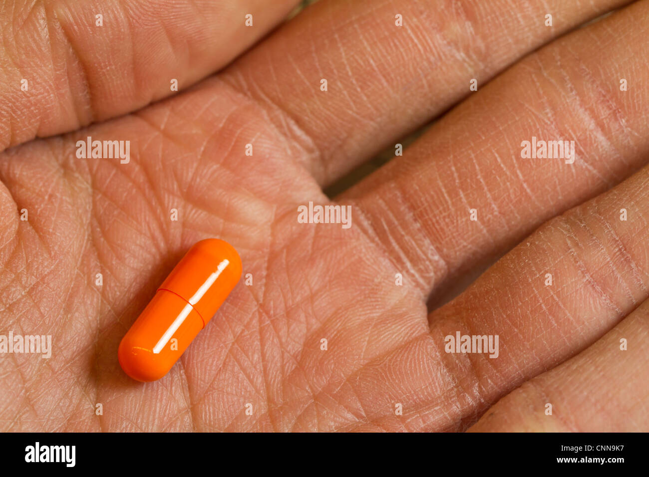 Handfläche der Hand, die eine Kapsel/Medikamente Stockfoto