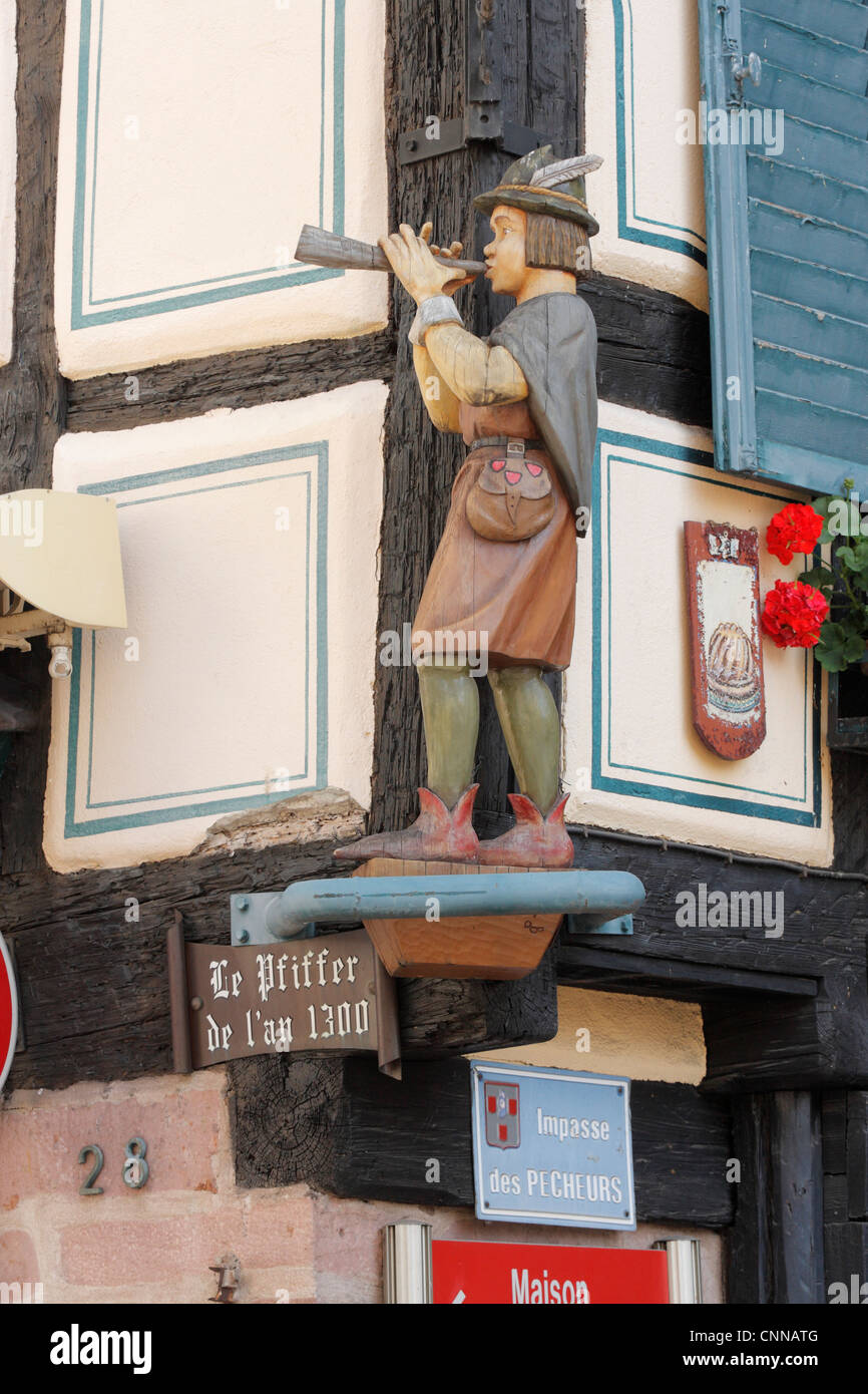 Geschnitzte Holzfigur von Piper auf eine mittelalterliche halbe Fachwerkhaus Mittagsmenue Elsass Frankreich Stockfoto