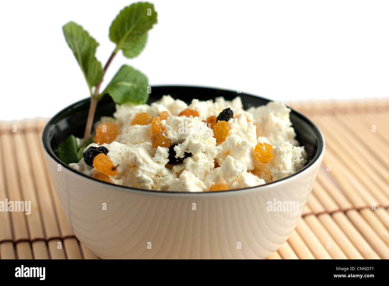 Runde Schale mit einem köstlichen Käse-Sahne und Rosinen. Isoliert auf weiss Stockfoto