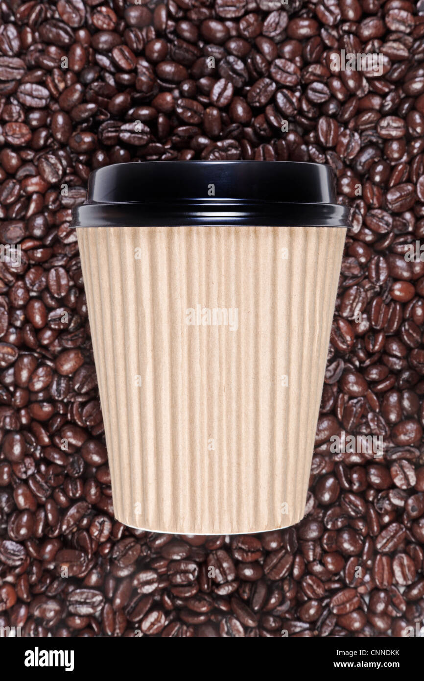 Foto von einem Einweg-Pappbecher Kaffee mit einer Mischung aus Arabica und Robusta Bohnen im Hintergrund. Stockfoto