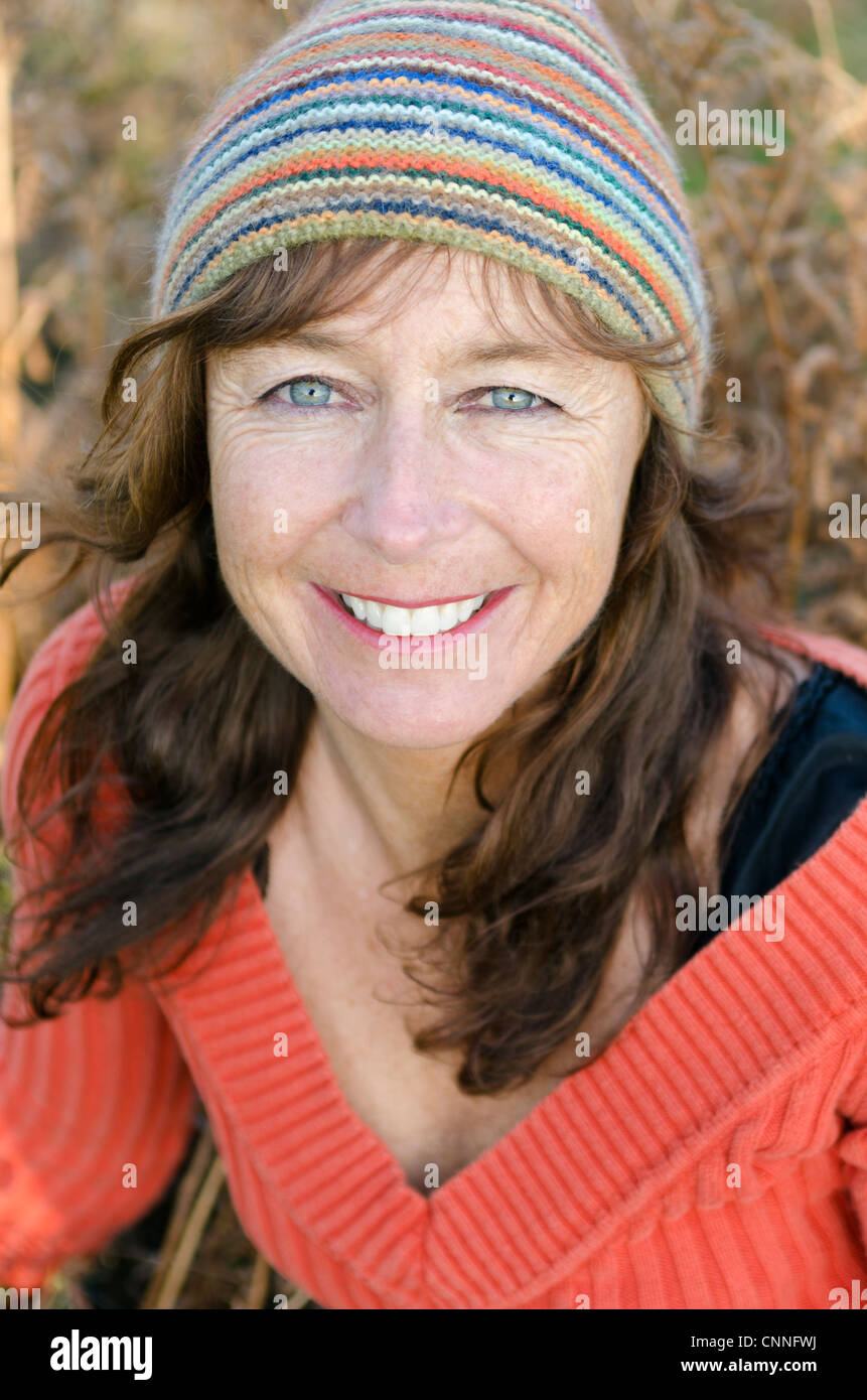 Ein Farbfoto Porträt der glücklich lächelnde Reife Frau in den Vierzigern, eine bunte Mütze Hut Stockfoto