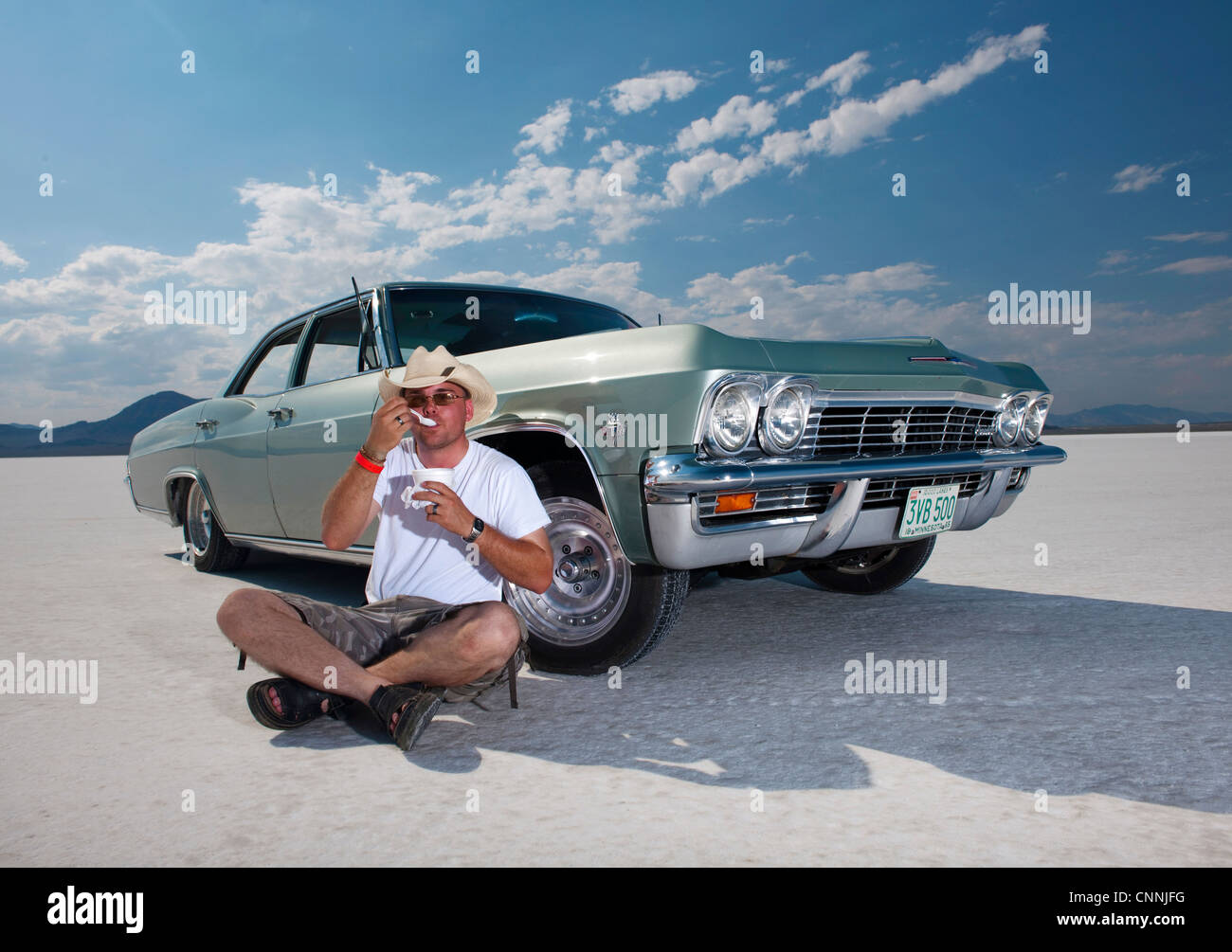 Mann saß am Salzsee von Bonneville mit klassischen Oldtimer Essen Stockfoto