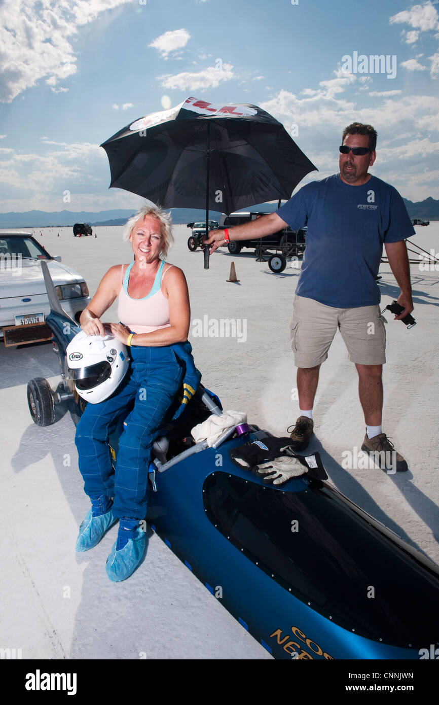 blaues Top Fuel Drag Race Auto mit Frau Treiber Unterständen aus Sonne unter Dach am Bonneville Salt Flat Geschwindigkeit Woche Stockfoto