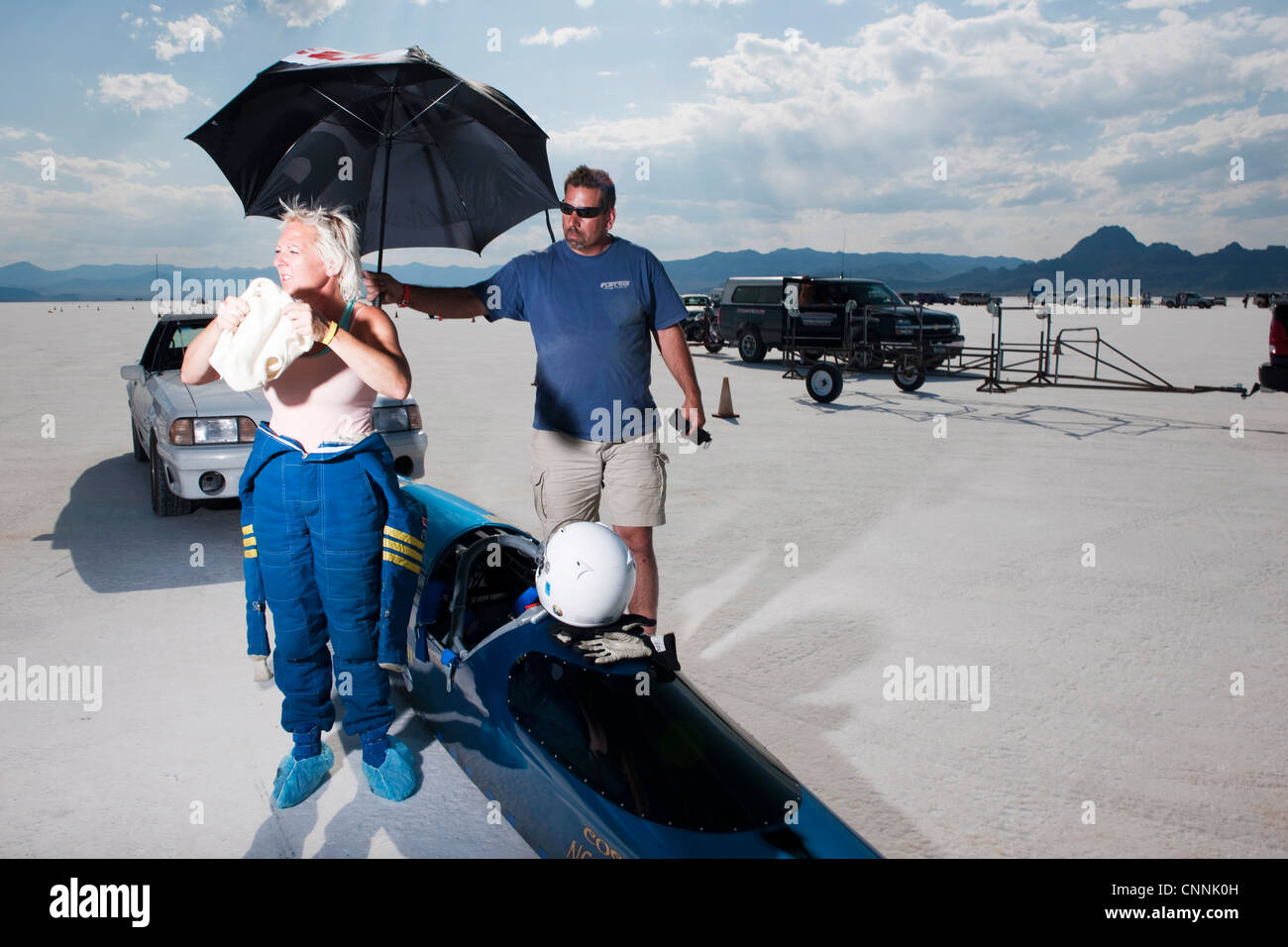blaues Top Fuel Drag Race Auto mit Frau Treiber Unterständen aus Sonne unter Dach am Bonneville Salt Flat Geschwindigkeit Woche Stockfoto
