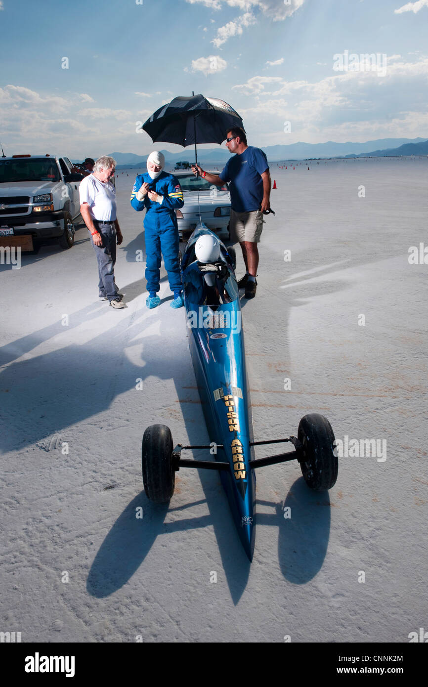 blaues Top Fuel Drag Race Auto mit Frau Treiber Unterständen aus Sonne unter Dach am Bonneville Salt Flat Geschwindigkeit Woche Stockfoto