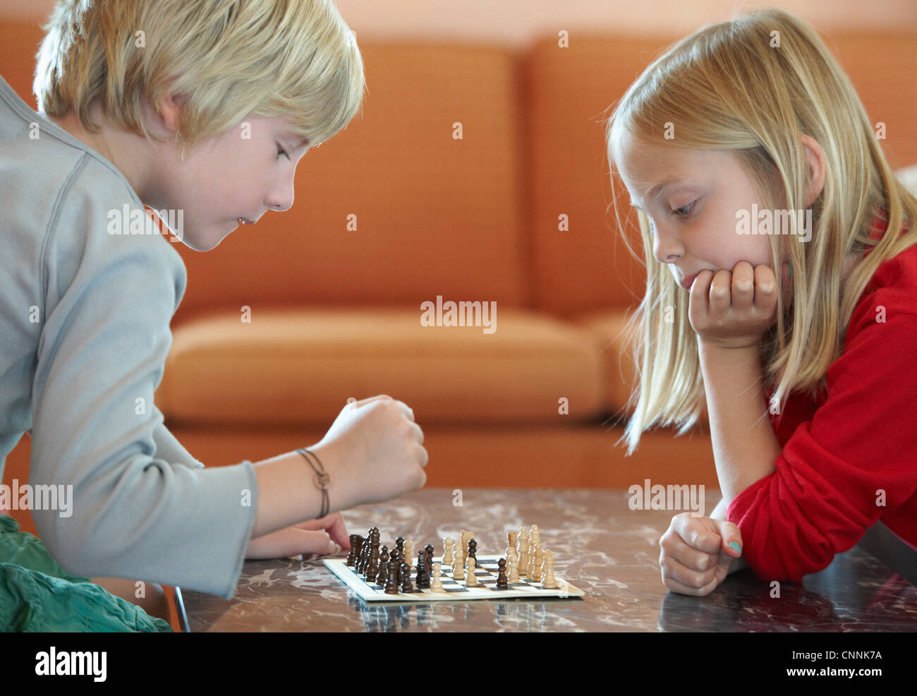 Kinder spielen Schach im Wohnzimmer Stockfoto