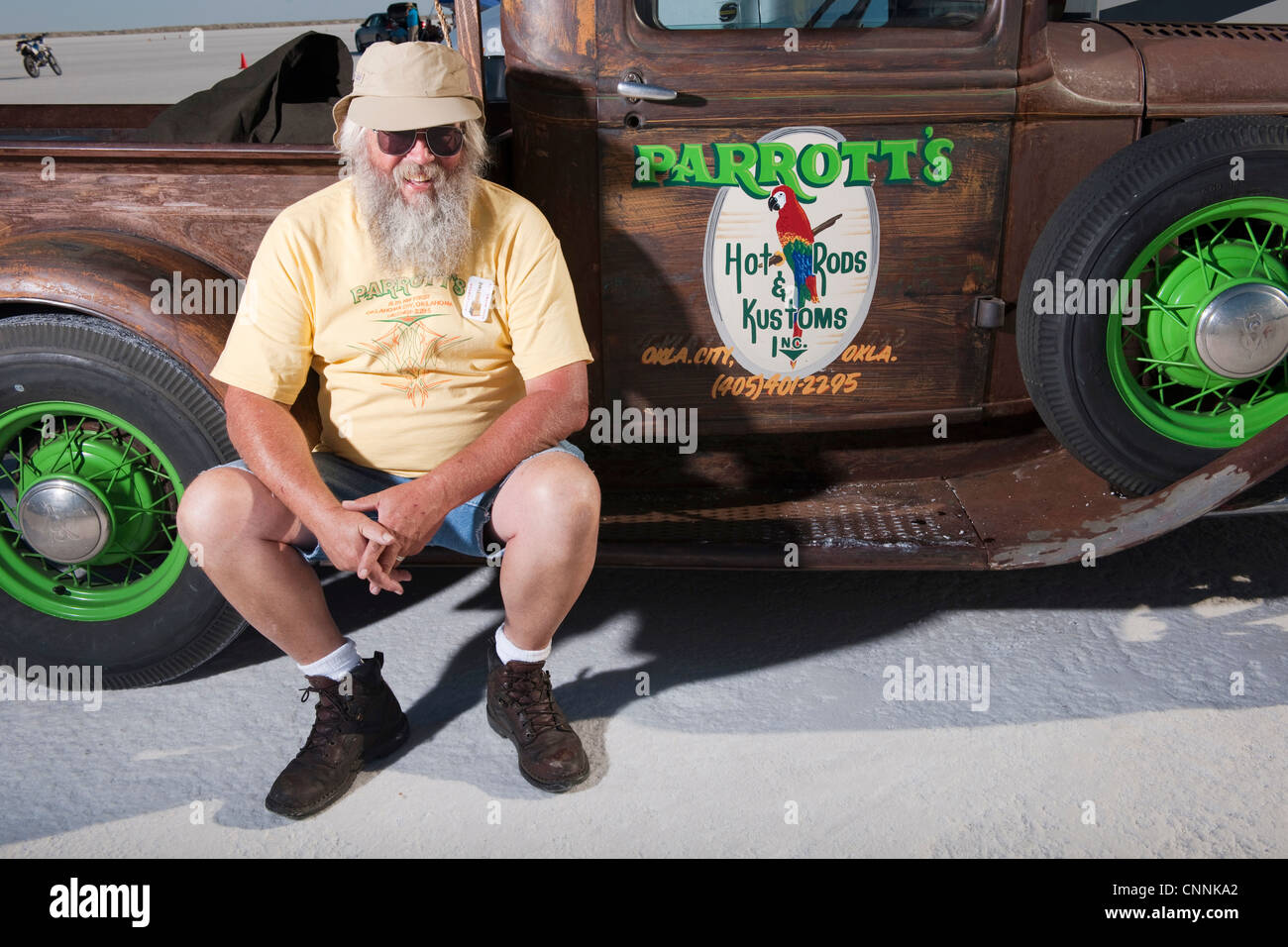 Alter Mann mit Bart saß am Salzsee von Bonneville mit Vintage classic LKW Stockfoto