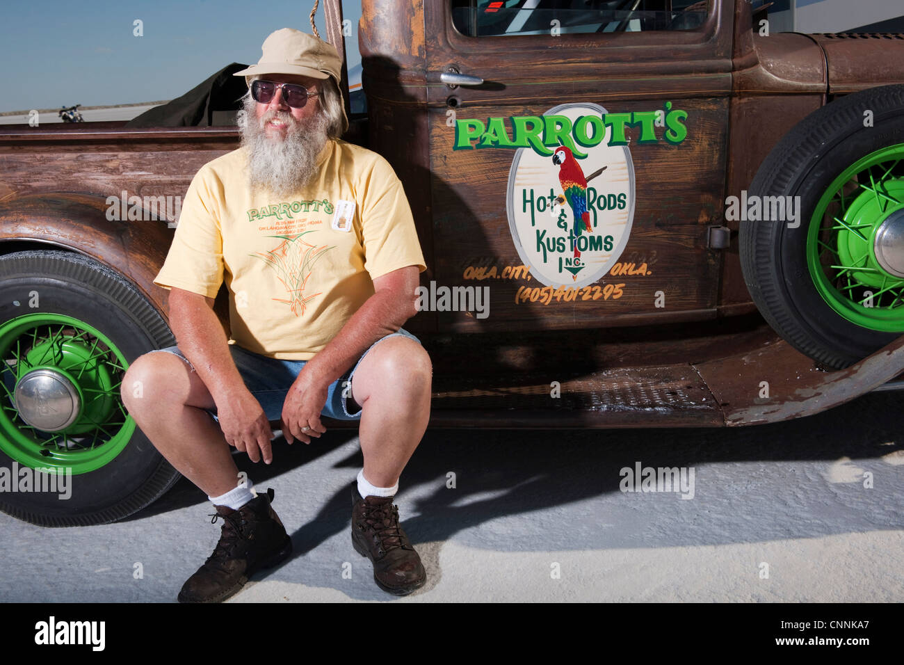 Alter Mann mit Bart saß am Salzsee von Bonneville mit Vintage classic LKW Stockfoto