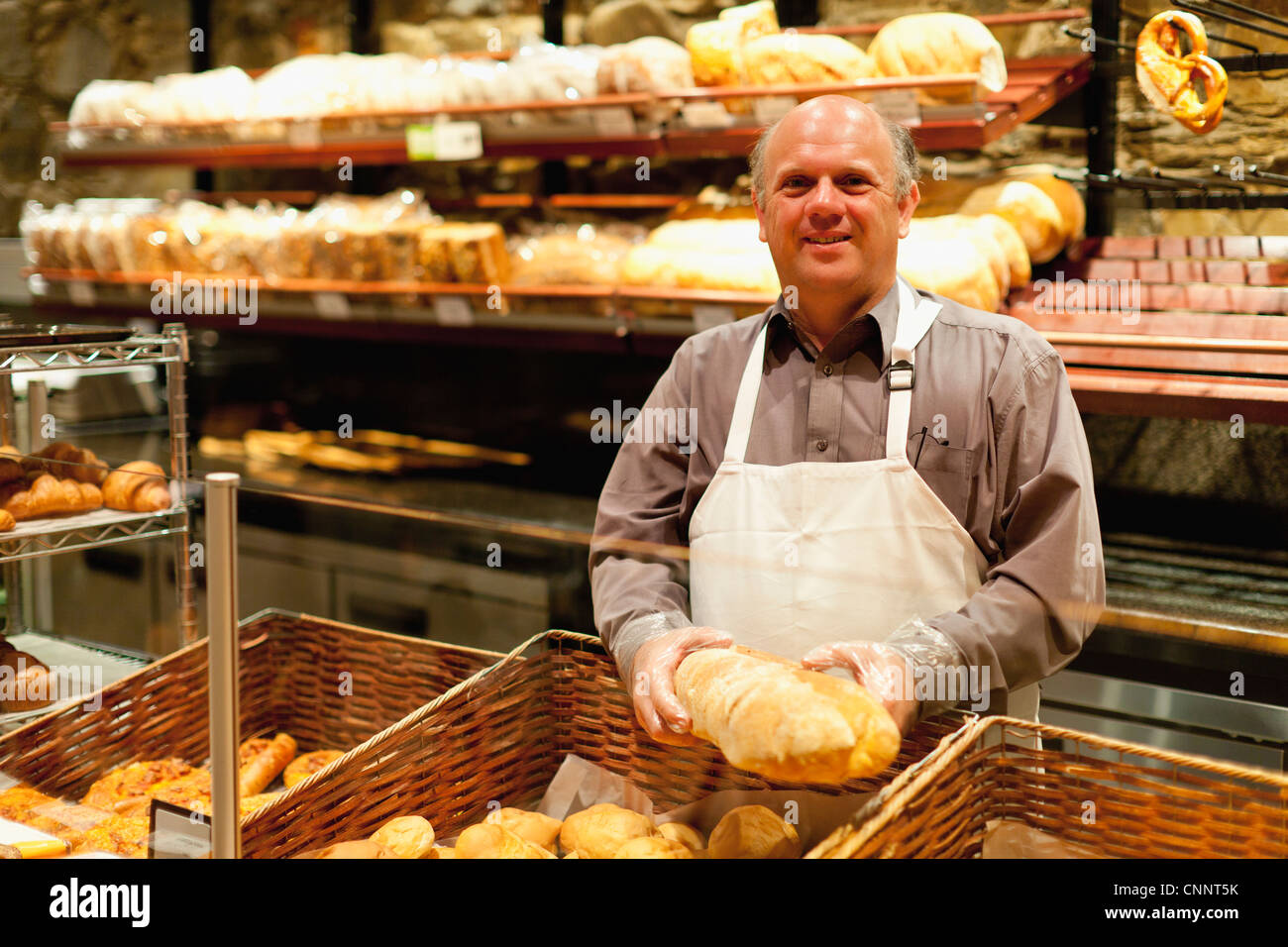 Lächelnd hält Laib Brot Bäcker Stockfoto