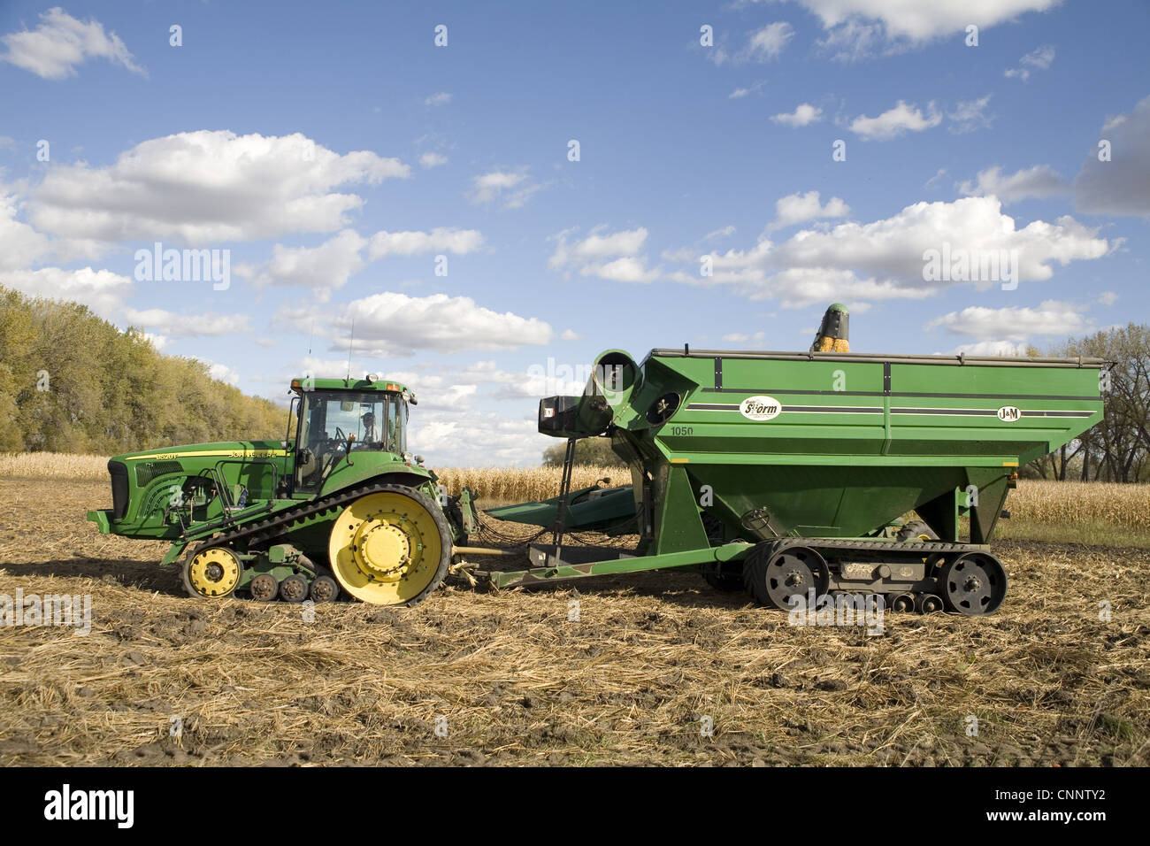 Mais Zea Mays Zuschneiden John Deere 8520T verfolgt Traktor verfolgte Getreide Wagen geladen werden bei der Ernte South Dakota USA Oktober Stockfoto