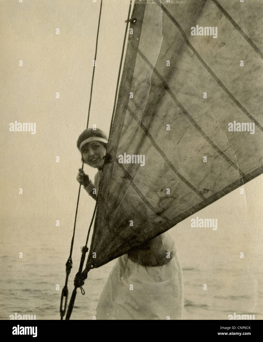Ca. 1920er Jahre Frau versteckt sich hinter einem Fock Segel auf einem Boot, USA. Stockfoto