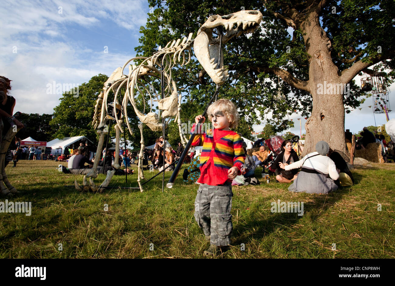Kind spielt mit eine Leben-Replik des Spielgruppe Festival in Kent ein Dinosaurier-Skelett. Stockfoto