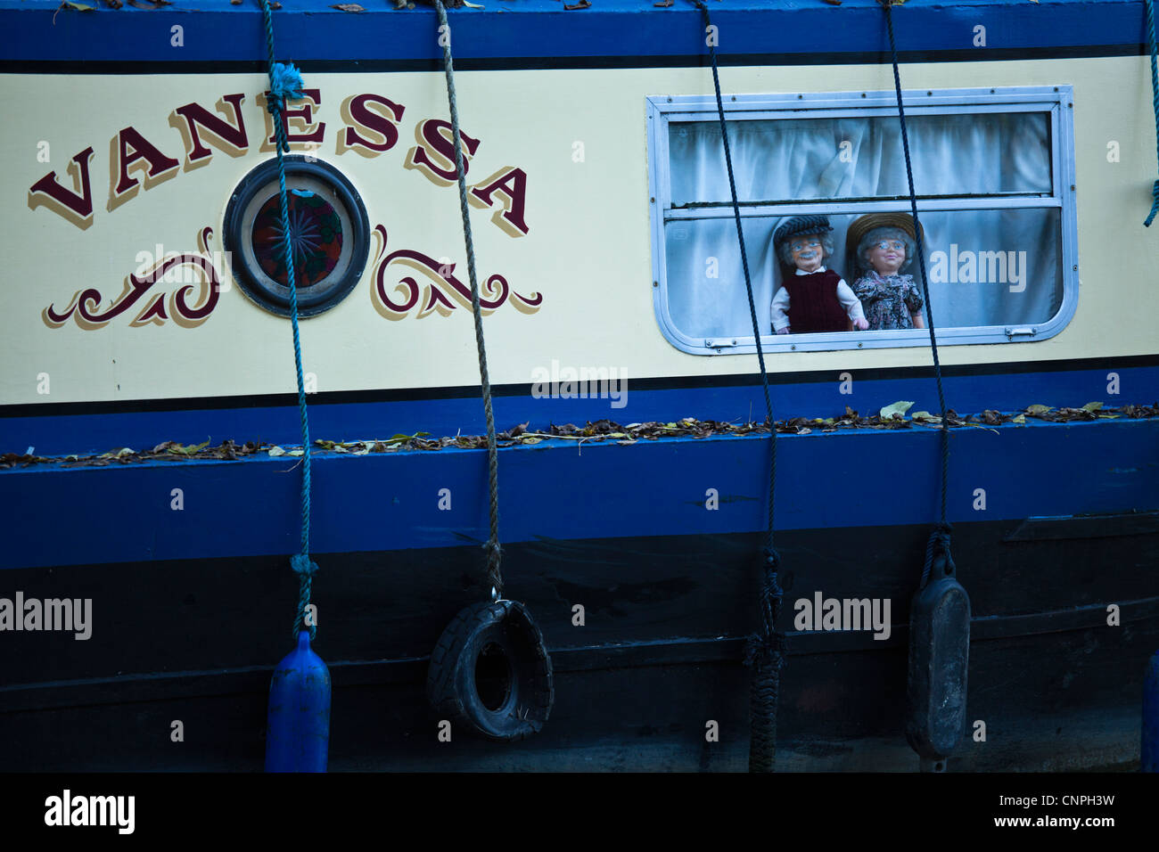 Zwei Puppen starren aus einem Kanal-Boot-Fenster am Grand Union Canal in der Nähe von Milton Keynes, UK. Stockfoto