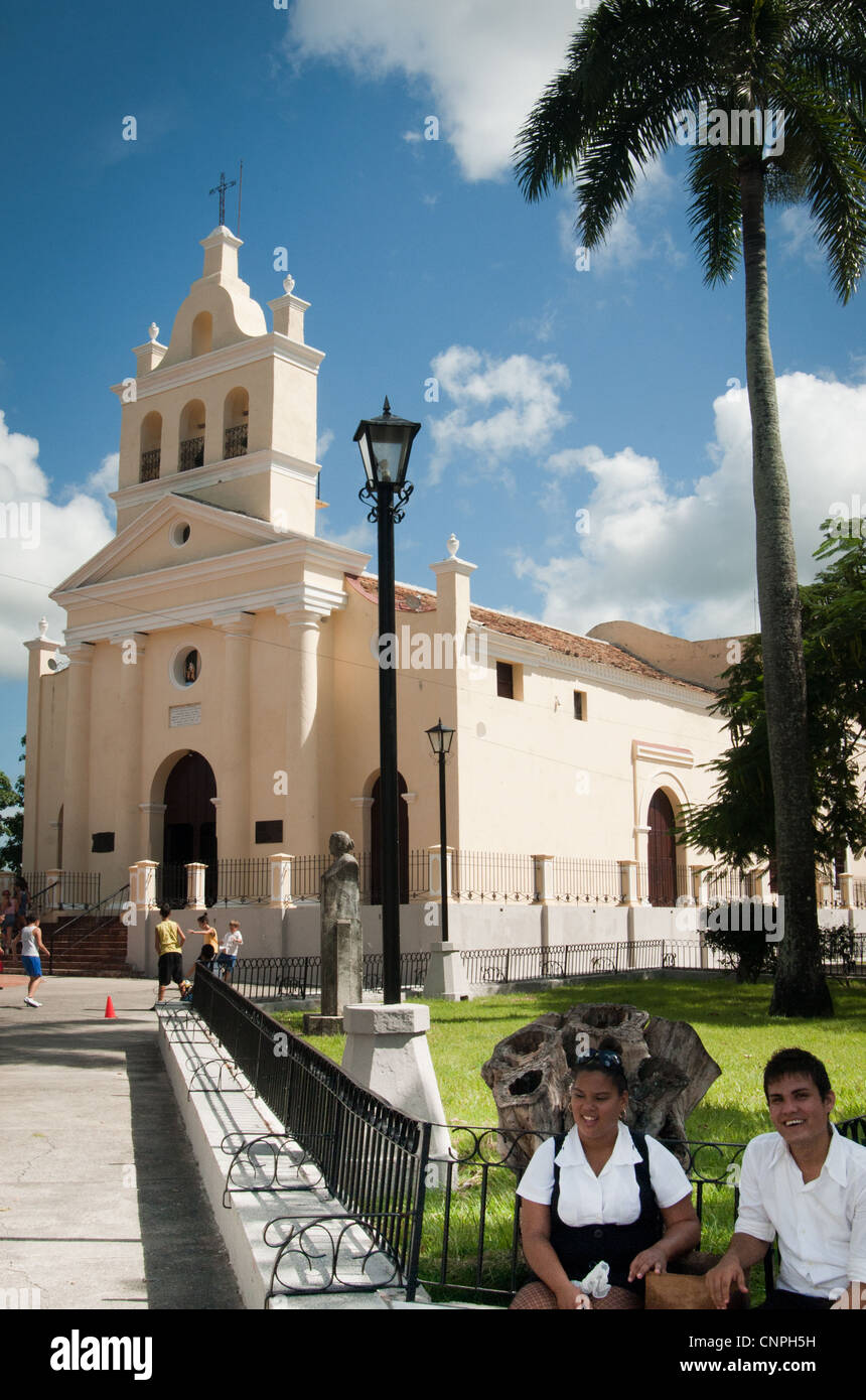 Zwei kubanischen Teenager in Schuluniformen sitzen außerhalb einer drei-Glocken-Kirche in Santa Clara, Kuba Stockfoto