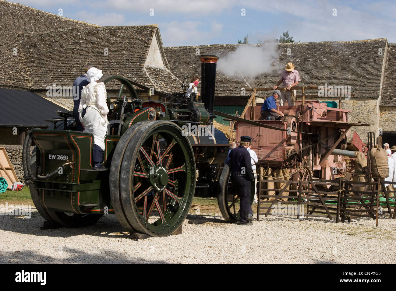 Dampftraktor getrieben Dreschmaschine auf dem Hof Stockfoto