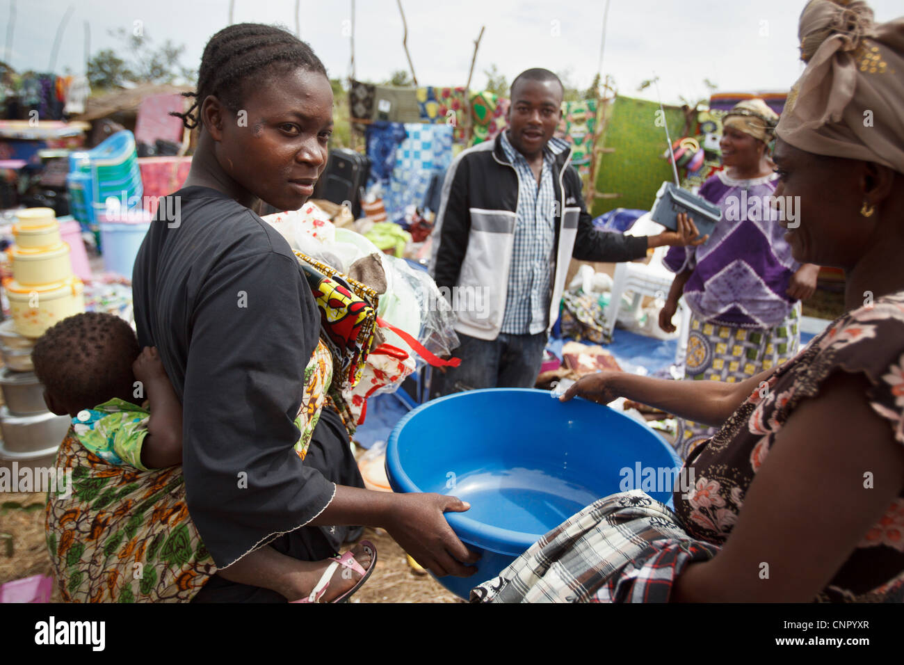Eine Frau kauft für Kunststoffbehälter während einer non Food-Artikel fair in der Siedlung Miketo IDP, Provinz Katanga der Demokratischen Republik Kongo Stockfoto
