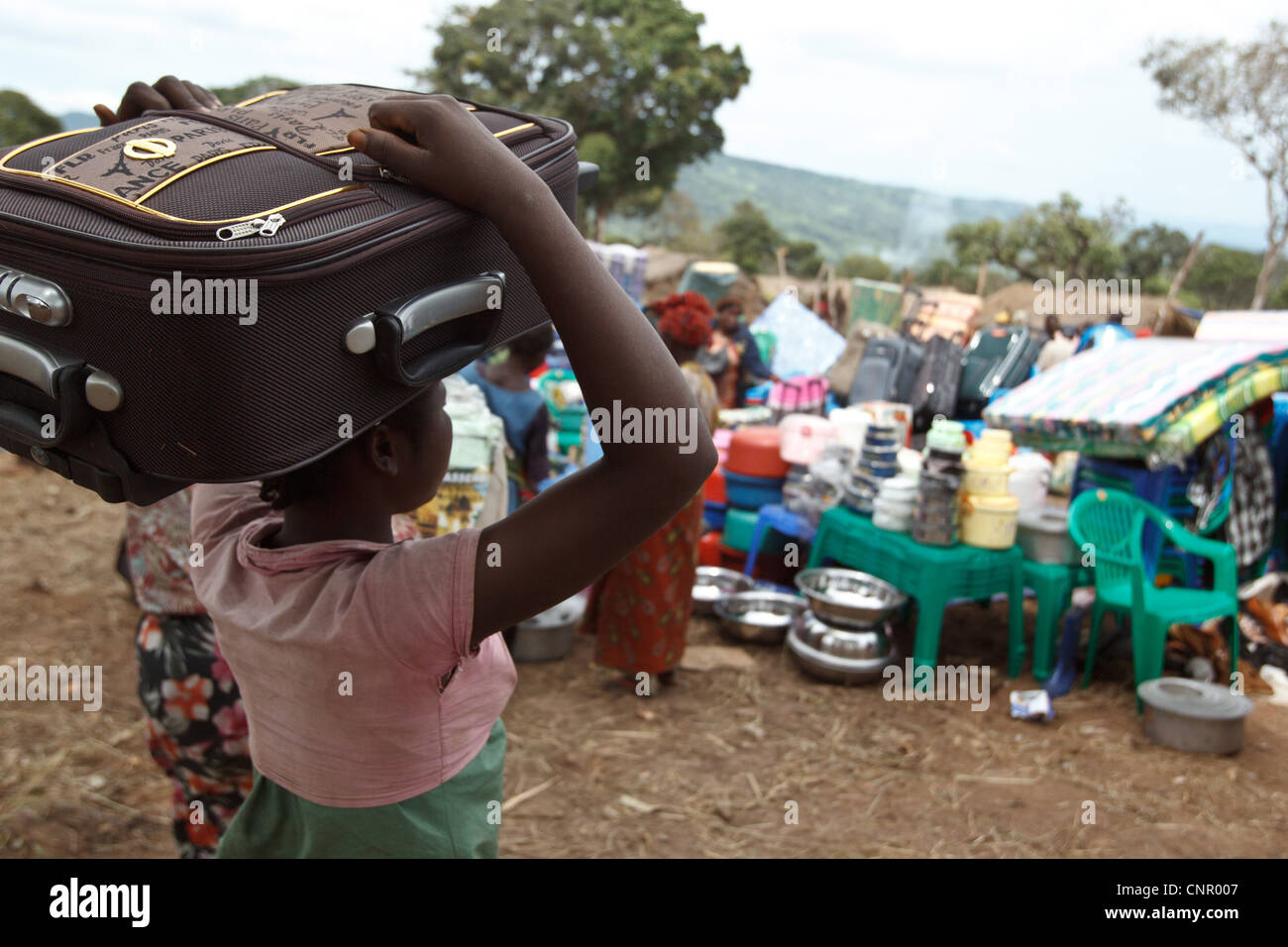 Eine Frau trägt einen Koffer, die, den Sie bei einem non Food-Artikel in der Siedlung Miketo IDP, Provinz Katanga, demokratische Republik Kongo fair gekauft Stockfoto