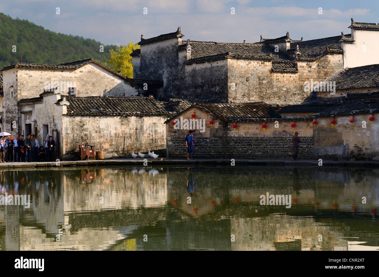 Alte Gebäude mit Gänsen und Touristen spiegelt sich im Teich noch Halbmond in Hongcun Dorf Peoples Republic Of China Stockfoto