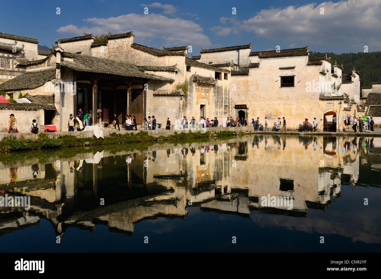 Alten weißen Gebäuden und Touristen spiegelt sich in den Teich noch Halbmond in Hongcun Dorf Peoples Republic Of China Stockfoto