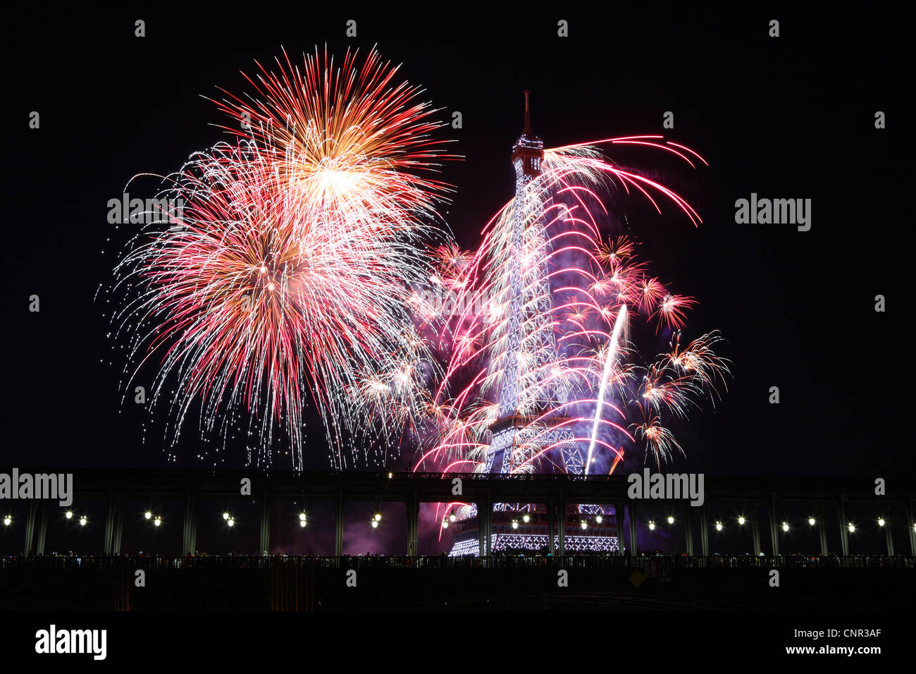 Parisern und Touristen beobachten Bastille Day Feuerwerk rund um den Eiffelturm mit Passy Brücke im Vordergrund in Paris, Frankreich. Stockfoto