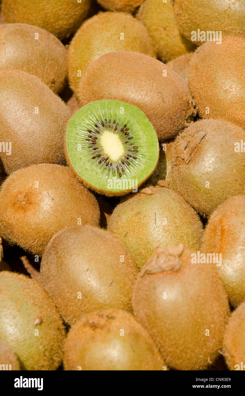 Gestapelte Kiwis, eine in Scheiben geschnitten in Hälfte, UK Stockfoto