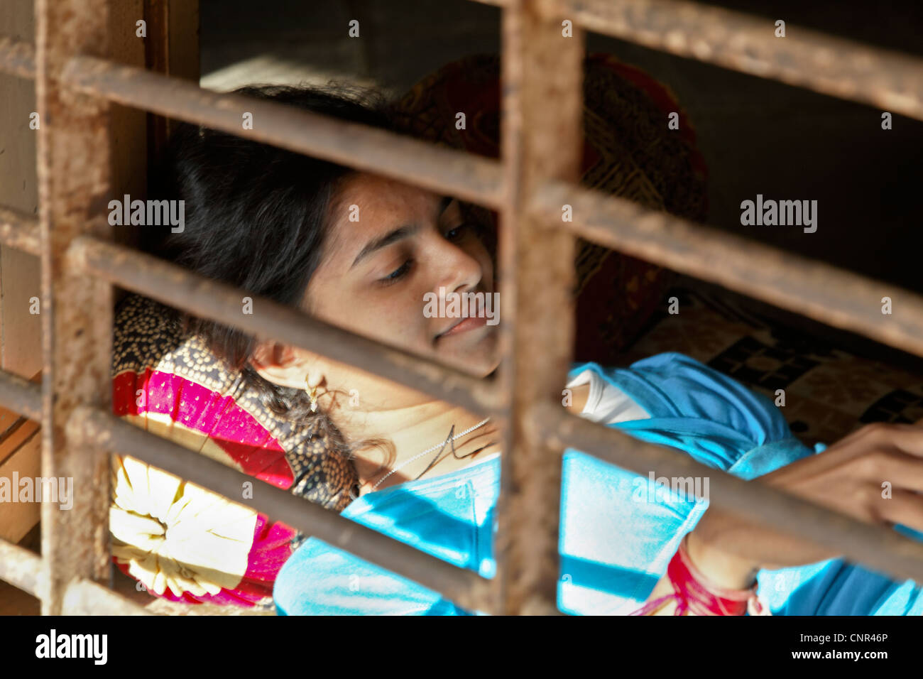 Landleben in Indien, entspannt junge Dame am offenen Fenster die Sonnenstrahlen an Stockfoto