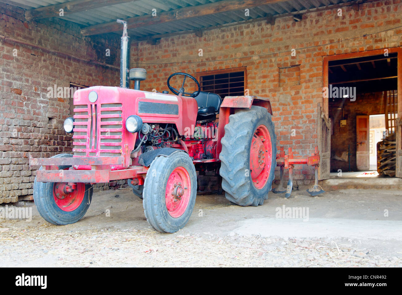 Landschaft des indischen Traktor geparkt in einem Stall mit Pflügen Anlage Stockfoto