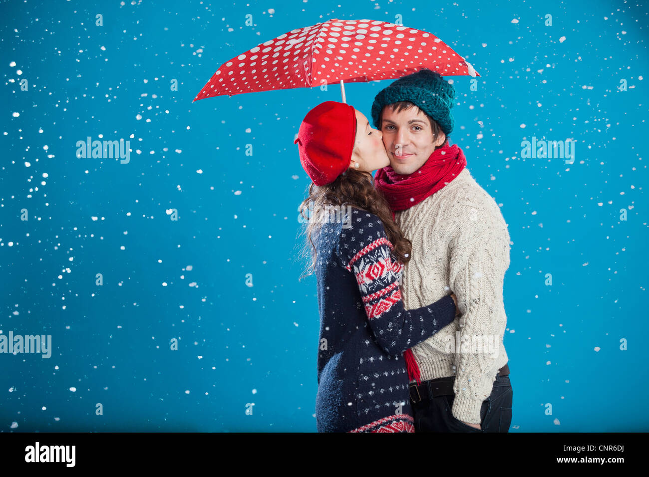 Lächeln, paar küssen im Schnee Stockfoto