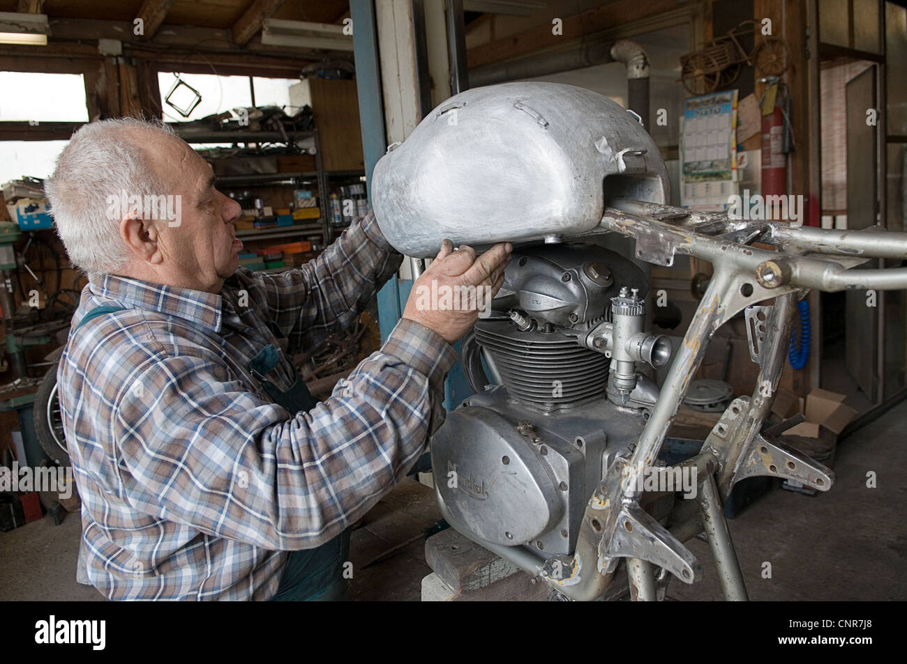 Mann ein Oldtimer Motorrad zu reparieren Stockfoto