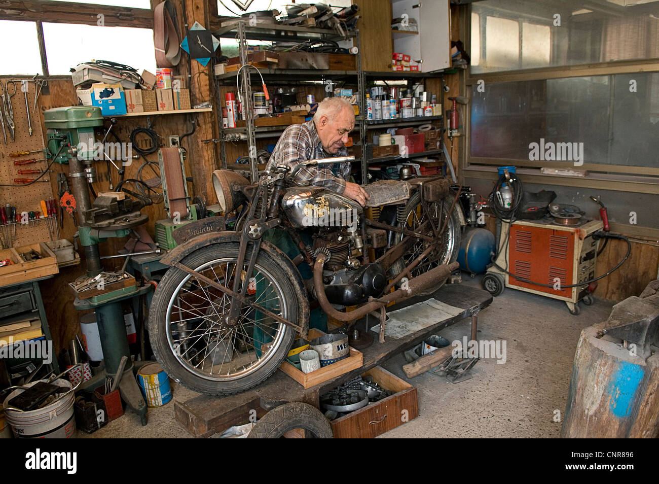 Mann in seiner Werkstatt ein Oldtimer Motorrad zu reparieren  Stockfotografie - Alamy