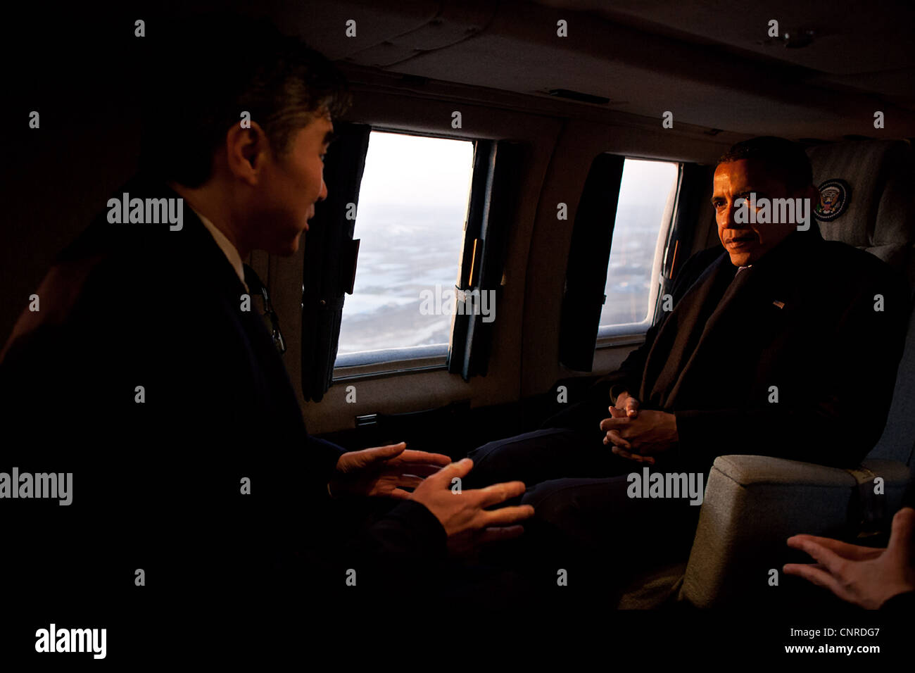 Präsident Barack Obama spricht mit Sung Kim, US-Botschafter in Südkorea, an Bord der Marine One während eines frühen Morgenflug von Osan Air Base in der Landezone am U.S. Army Garrison Yongsan 25. März 2012 in Seoul, Südkorea. Stockfoto