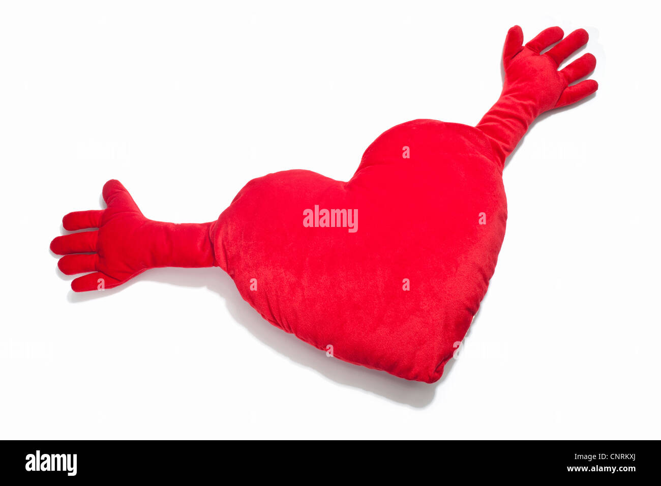 Ein rotes Herz geformten Kissen mit ausgestreckten Händen Stockfoto