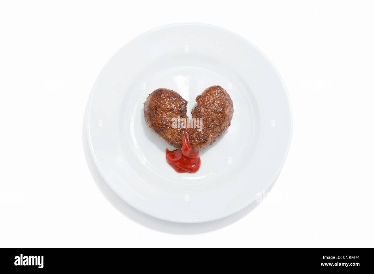 Eine herzförmige Beef-Burger auf dem Teller mit Tomatensauce Nässen aus es Stockfoto