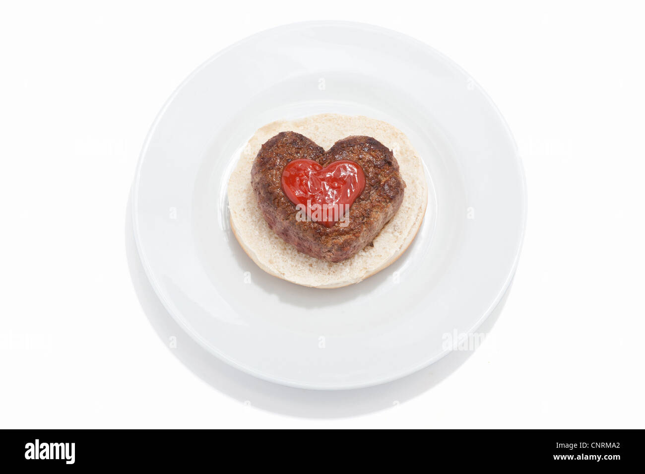 Eine herzförmige Beef-Burger auf einem Brötchen mit Tomatensauce Stockfoto