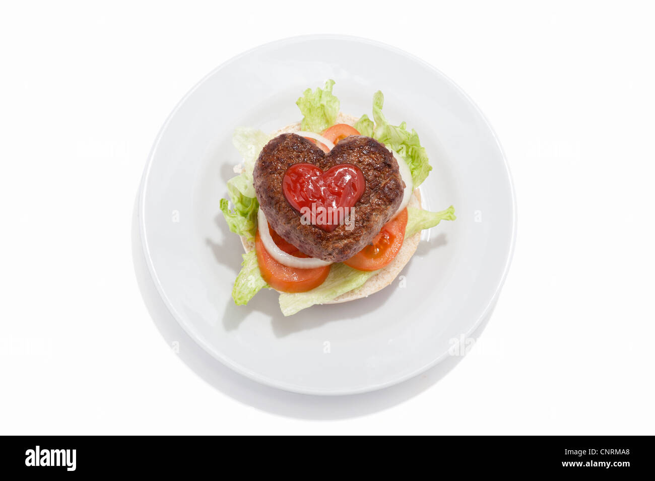 Eine herzförmige Beef-Burger und Salat auf einem Brötchen mit Tomatensauce Stockfoto