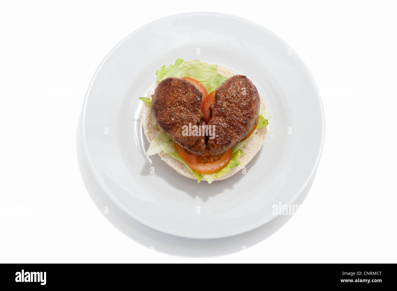Ein gebrochenes Herz geformt, Beef-Burger und Salat auf einem Brötchen Stockfoto