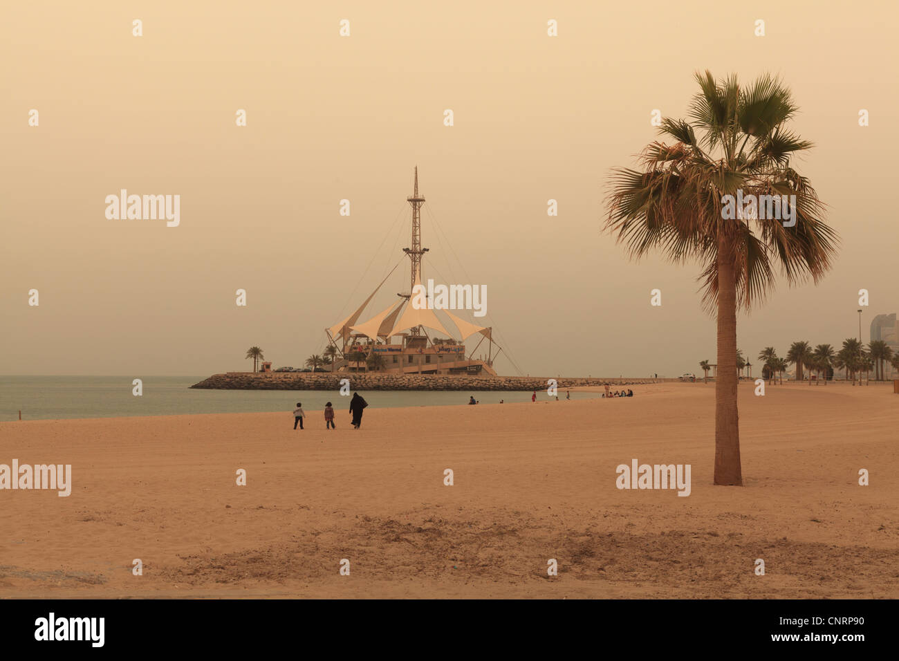 Ein Strand in Kuwait-Stadt mit der Marina Wellen Gebäude im Hintergrund Stockfoto