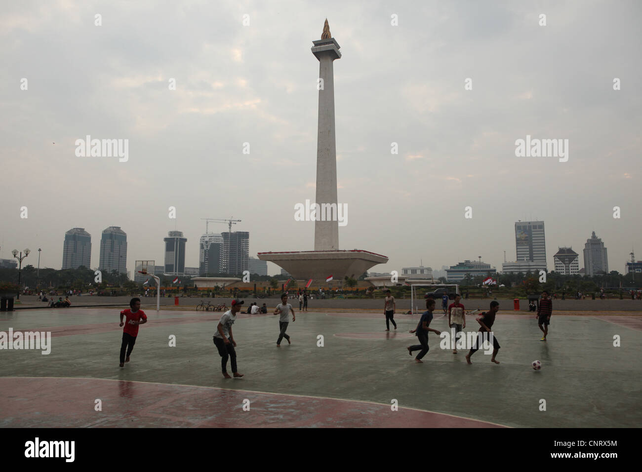 Kinder plat Fußball am Fuße des National Monument oder die Monas in Jakarta, Indonesien. Stockfoto