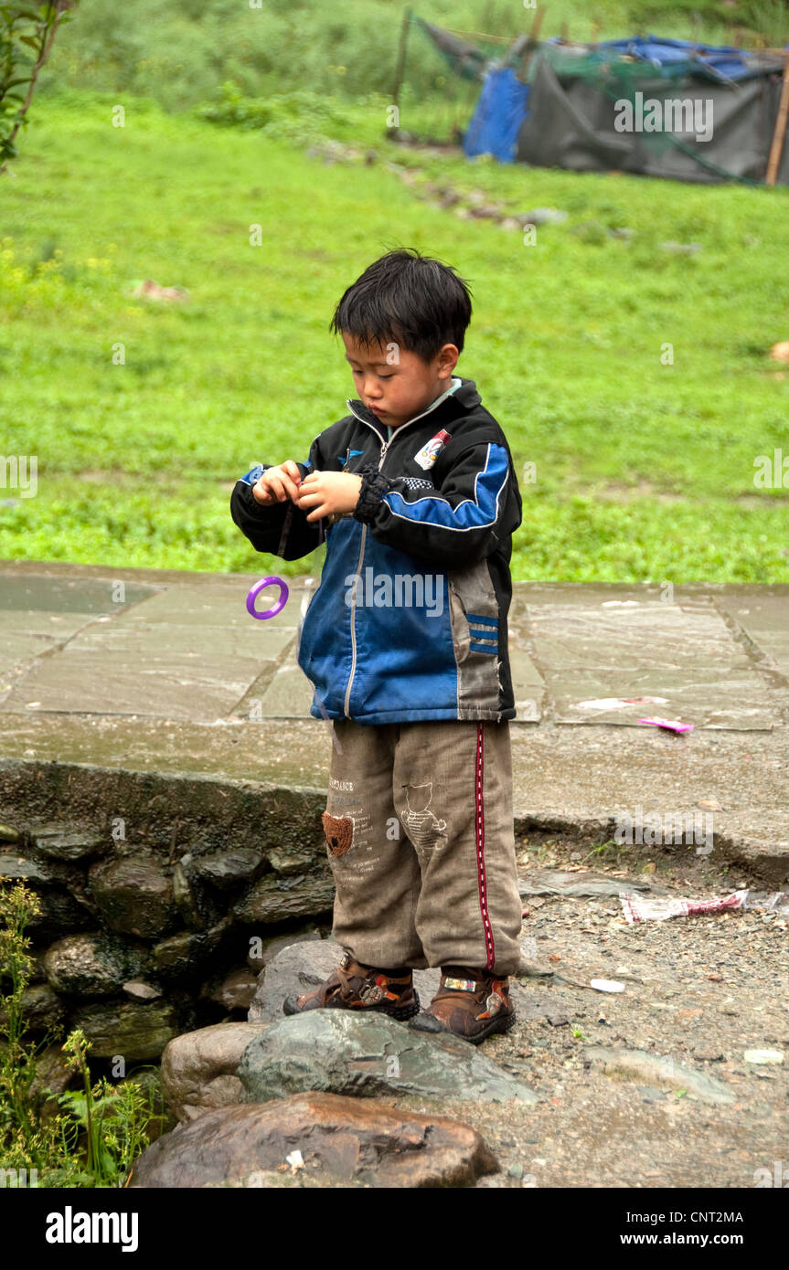 Chinesisches Kind, das bei einem Jo-Jo im Dorf Dazhai, Provinz Guangxi, China, zahle Stockfoto