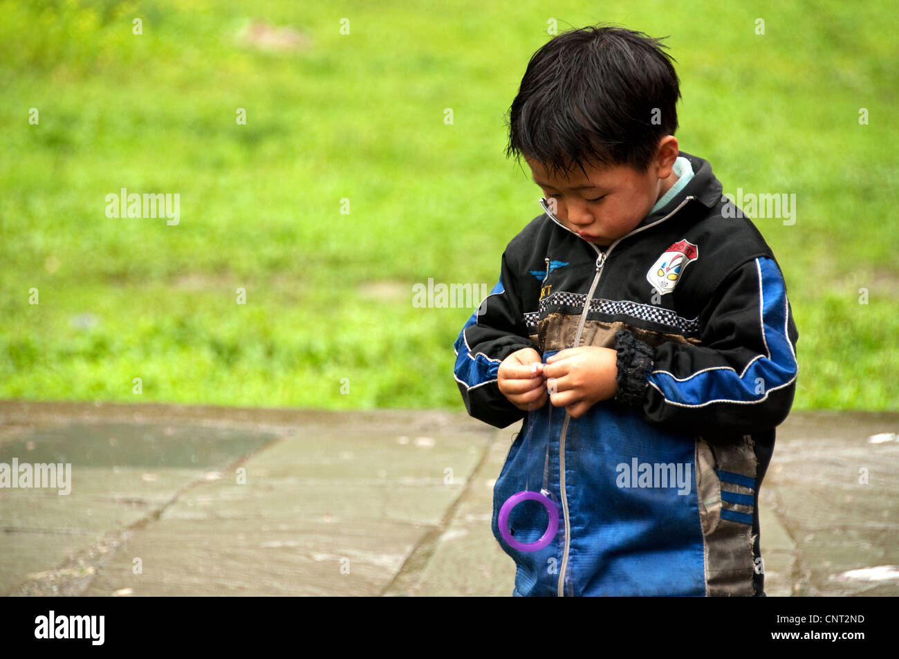 Chinesisches Kind, das bei einem Jo-Jo im Dorf Dazhai, Provinz Guangxi, China, zahle Stockfoto