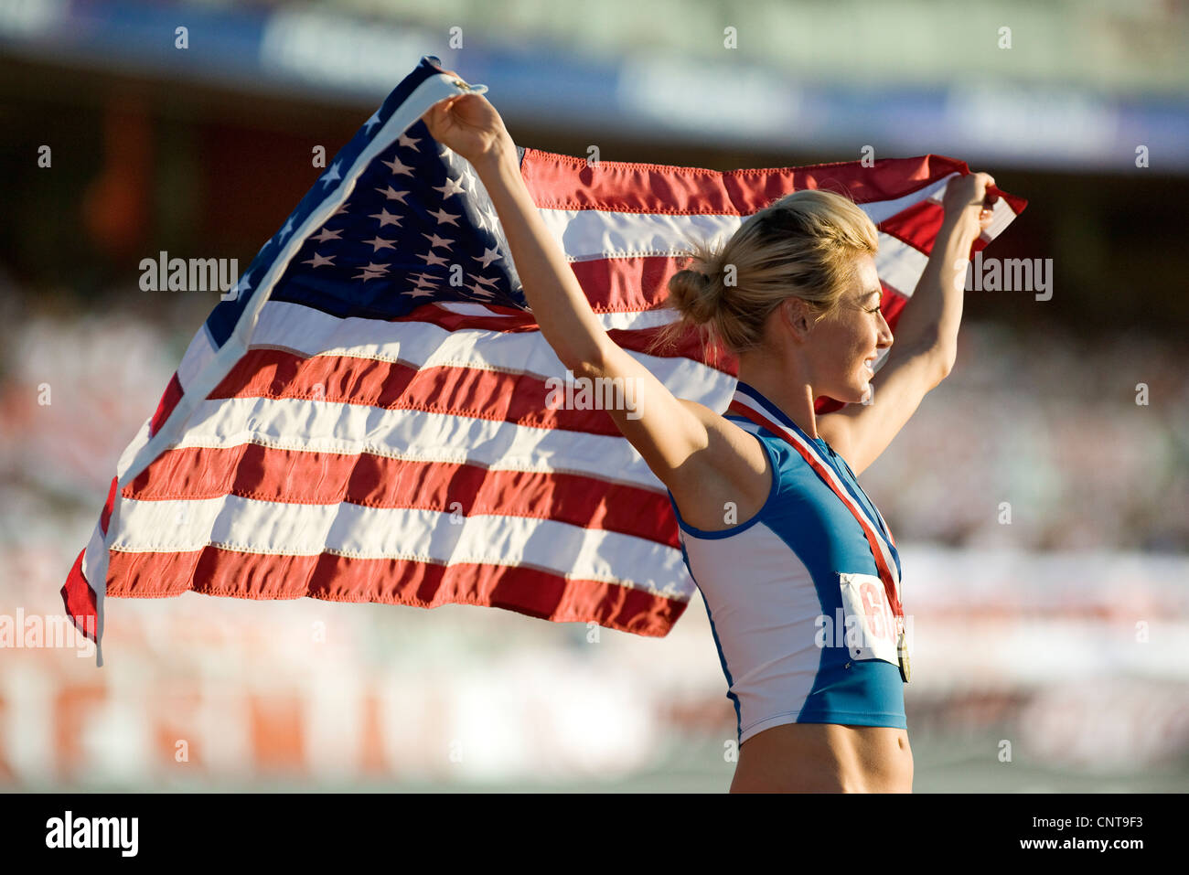 Weiblichen Medaillengewinner, die amerikanische Flagge hochhalten Stockfoto