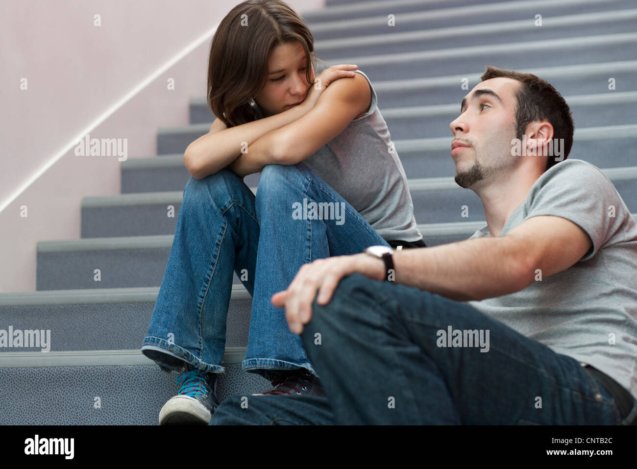 Junges Paar auf Treppe miteinander reden Stockfoto