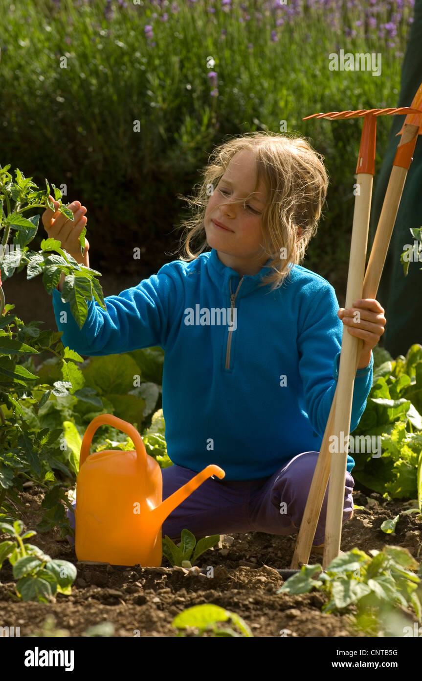 8 Jahre altes Mädchen im Garten, Frankreich Stockfoto