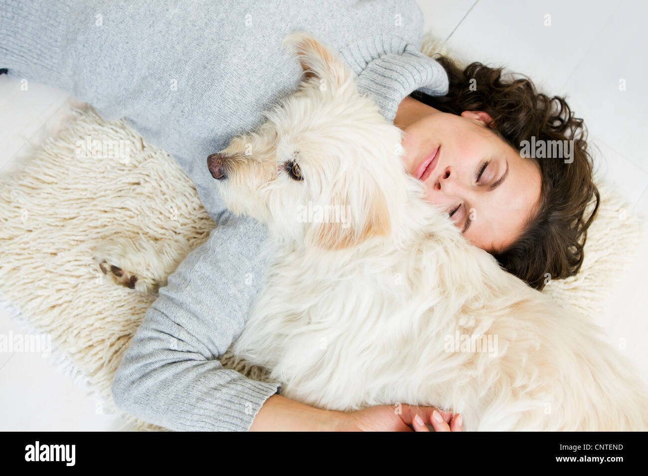 Frau mit Hund auf Teppich Stockfoto