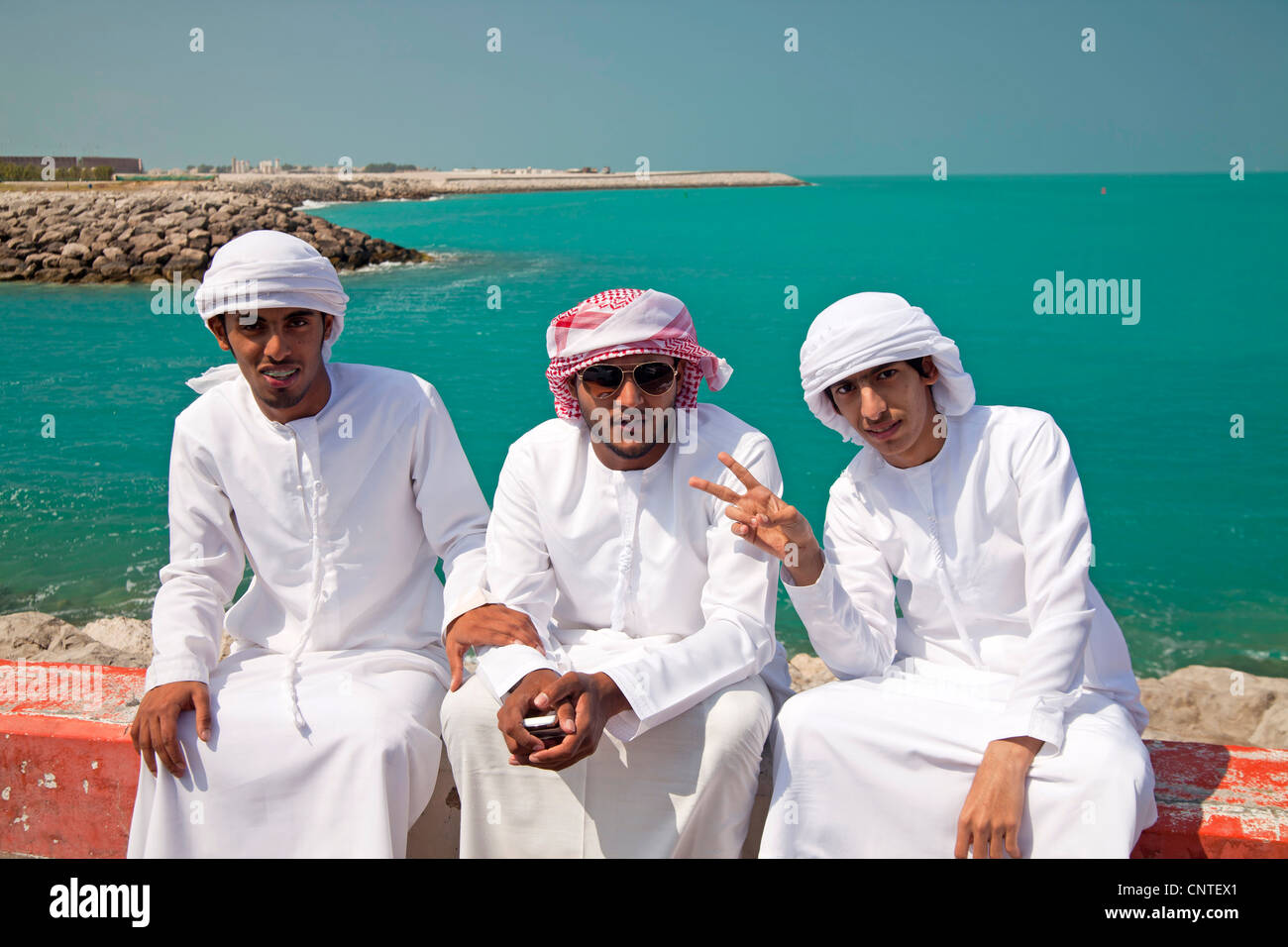 jungen männliche Einheimischen mit ihren typischen traditionellen arabischen Kleid Kandora oder Dishdasha, Abu Dhabi, der Hauptstadt der Vereinigten Arabischen E Stockfoto