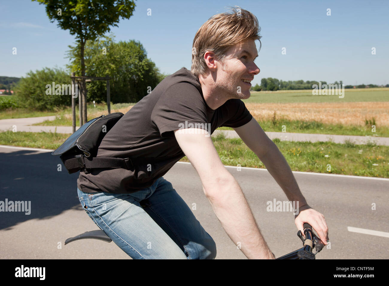 Mann Reiten Fahrrad auf Landstraße Stockfoto