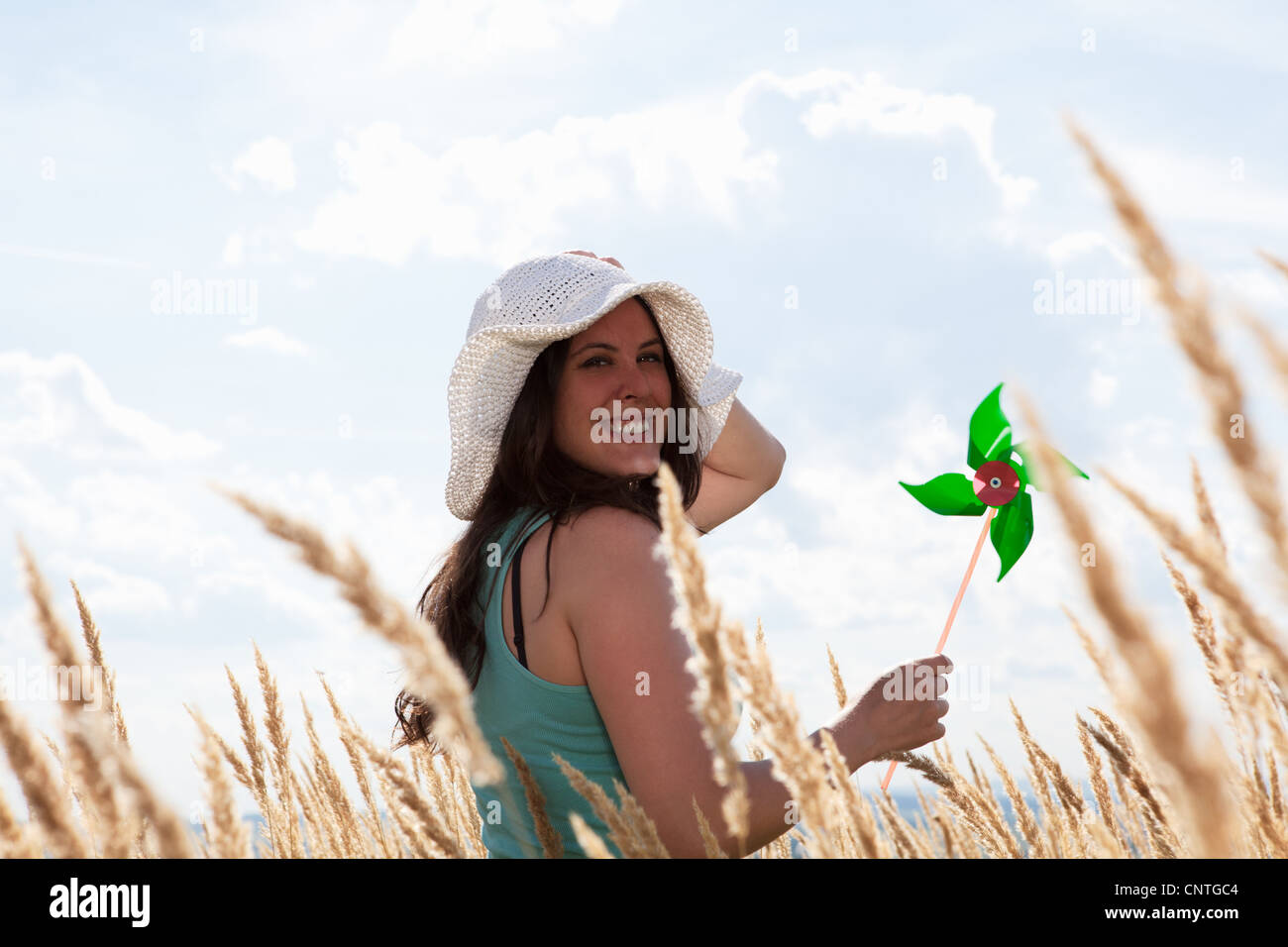 Frau Holding Windrad im Weizenfeld Stockfoto
